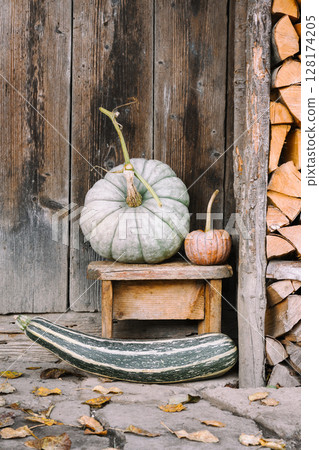Assorted pumpkins near a wooden barn door on a village courtyard Assorted pumpkins near a wooden barn door on a village courtyard 128174205