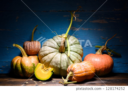 Rustic wooden table with assorted pumpkins forms 128174252