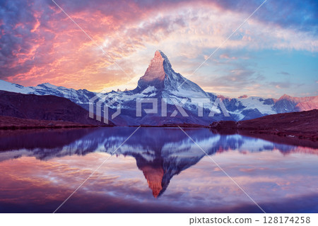 Stellisee lake glows at sunset with perfect Matterhorn reflection Stellisee lake glows at sunset with perfect Matterhorn reflection 128174258