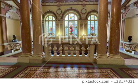 An Elegant Architectural Interior Showcasing Beautiful Stained Glass Windows and Majestic Pillars An Elegant Architectural Interior Showcasing Beautiful Stained Glass Windows and Majestic Pillars 128174321