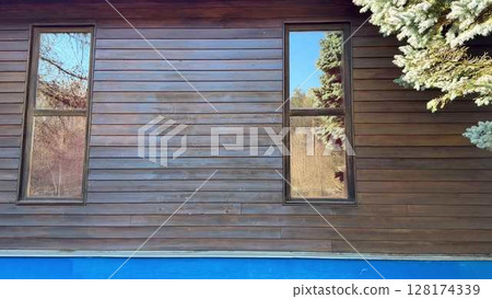 A stunning modern wooden house exterior with beautiful reflections and design elements 128174339
