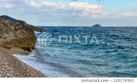 A tranquil coastal scene with a beautiful rocky shoreline and clear waters extending to the horizon A tranquil coastal scene with a beautiful rocky shoreline and clear waters extending to the horizon 128174363