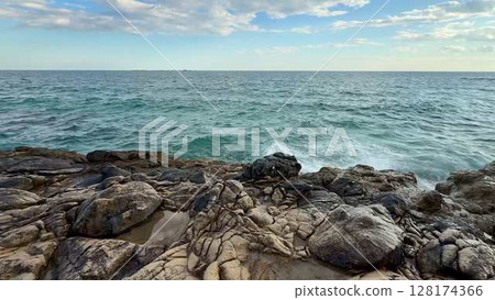 A Serene Coastal View Featuring Waves Gently Crashing Against the Rocky Shoreline A Serene Coastal View Featuring Waves Gently Crashing Against the Rocky Shoreline 128174366