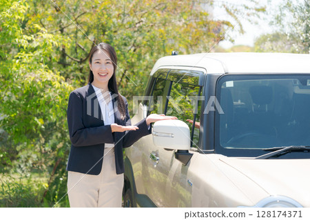 Businesswoman standing next to a car 128174371