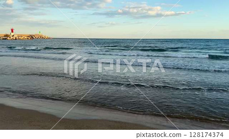 The Calm Waves Gently Lapping at Sunset on a Beautiful and Serene Seaside Beach Escape The Calm Waves Gently Lapping at Sunset on a Beautiful and Serene Seaside Beach Escape 128174374