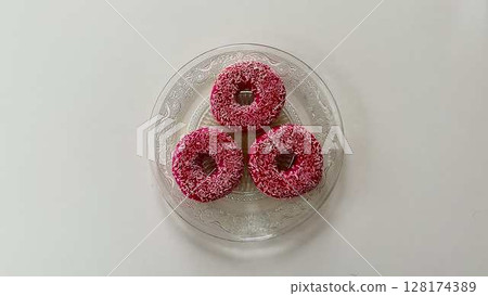 Temptingly Delicious Pink Donuts Artfully Displayed on a Beautiful Decorative Plate 128174389