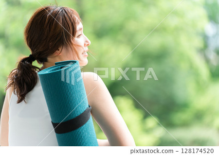 一個在公園裡做瑜珈來緩解壓力、提神醒腦的女人，瑜珈墊 128174520