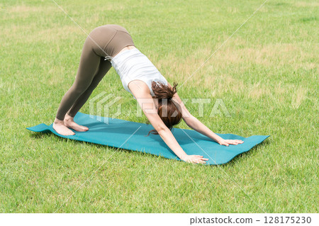 Young Asian woman doing park yoga, yoga pilates stretching in the park 128175230