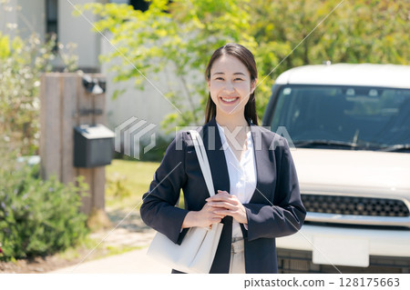 Businesswoman standing in front of a car 128175663