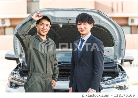 一名男工人和一名男司機趕到道路服務處。 一名男工人和一名男司機趕到道路服務處。 128176169