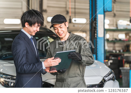 Mechanic and front man in the pit of a repair shop (diagnosis, maintenance, computer diagnosis) 128176387