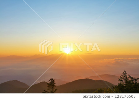 The sun at dawn from the Utsukushigahara Plateau in Nagano Prefecture 128176503