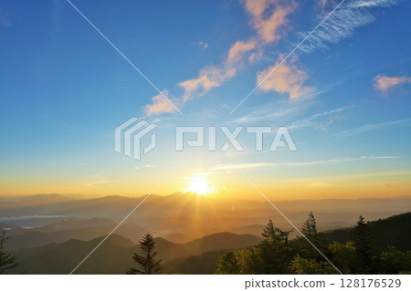 The sun at dawn from the Utsukushigahara Plateau in Nagano Prefecture 128176529