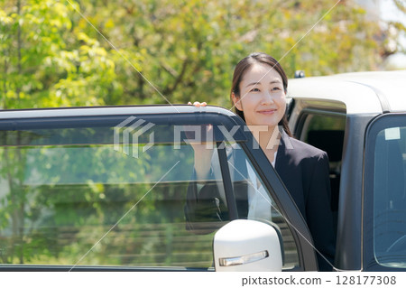 一名身穿西裝的女子坐在車裡 128177308