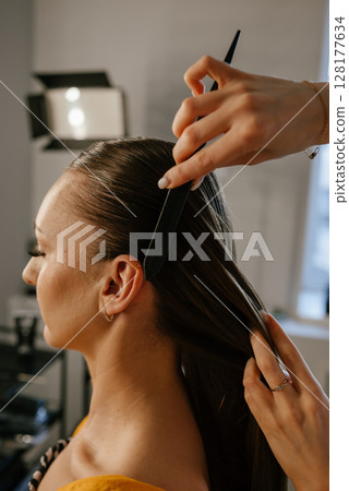 Hairstylist Creating Sleek Hairdo with Comb and Precision 128177634
