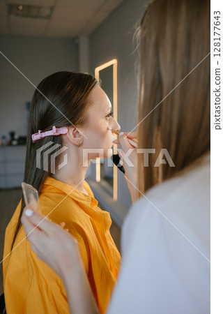 Makeup Artist Applying Blush on Woman's Cheek Makeup Artist Applying Blush on Woman's Cheek 128177643