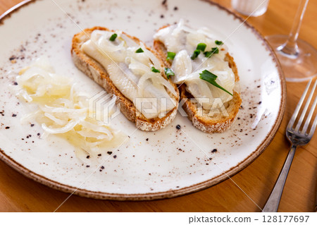 Sandwiches with salted herring fillet, pickled onions and scallions 128177697