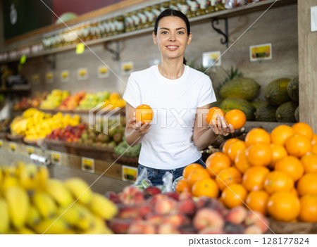 Adult woman choosing oranges at vegetable shop 128177824