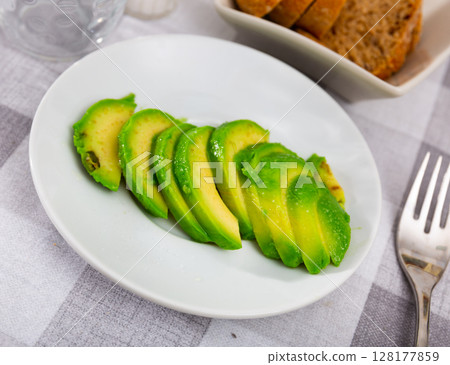 Beautifully sliced avocado with sesame seeds on a plate, serve the avocado on the festive table Beautifully sliced avocado with sesame seeds on a plate, serve the avocado on the festive table 128177859