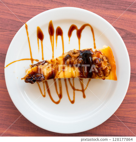 Appetizing piece of walnut pie on platter 128177864