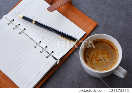 An image of a man working at his desk with a system organizer while drinking coffee with plenty of milk, or cafe au lait An image of a man working at his desk with a system organizer while drinking coffee with plenty of milk, or cafe au lait 128178233