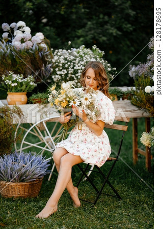 Woman Embracing Bouquet in Sunlit Garden 128178695