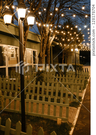 Enchanting Evening Garden with String Lights Across Path 128178704