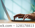 Hands typing on laptop with soft natural light for modern business workspace 128178813