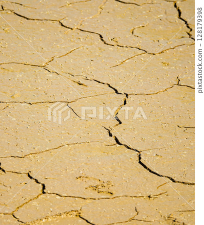 The cracked bottom of a lake that has dried up due to lack of water The cracked bottom of a lake that has dried up due to lack of water 128179398