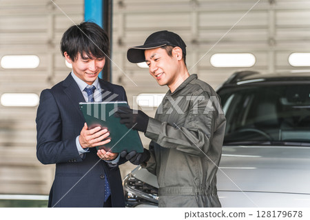 Mechanic and front man in the pit of a repair shop (diagnosis, maintenance, computer diagnosis) 128179678