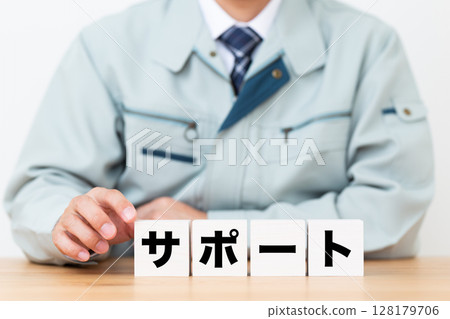 身穿工作服、手持支撐塊的中年男性商人 身穿工作服、手持支撐塊的中年男性商人 128179706