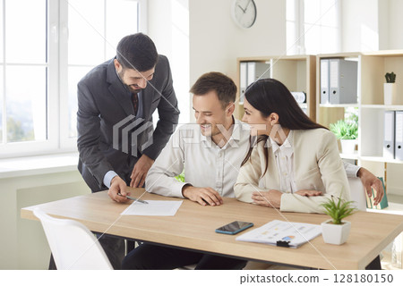 Corporate confident business people having a meeting in office looking through documents. 128180150