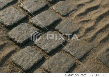 Rough gray cobblestone path with sand and visible texture in close up view 128181119