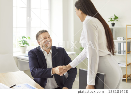 Happy office meeting, shaking successful smiling business candidate hand at meeting, congratulating  128181428