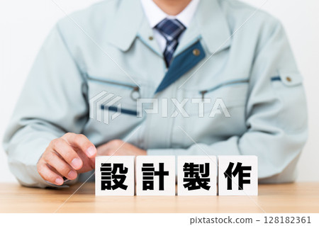 設計和生產塊和一位穿著工作服的中年男性商人 設計和生產塊和一位穿著工作服的中年男性商人 128182361