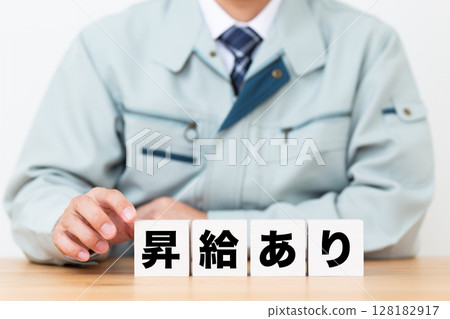 A middle-aged male businessman wearing work clothes and a block with a salary increase A middle-aged male businessman wearing work clothes and a block with a salary increase 128182917