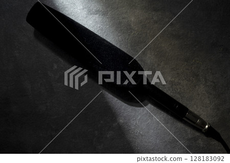 Studio microphone for podcasting or streaming with a black background. Top view 128183092