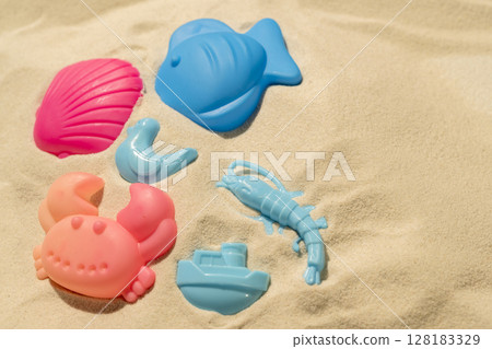 Beach toys on a beautiful sandy beach. Natural background. Summer concept. Top view Beach toys on a beautiful sandy beach. Natural background. Summer concept. Top view 128183329
