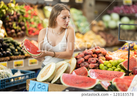 Woman near vegetable stand in store choose watermelon 128183578
