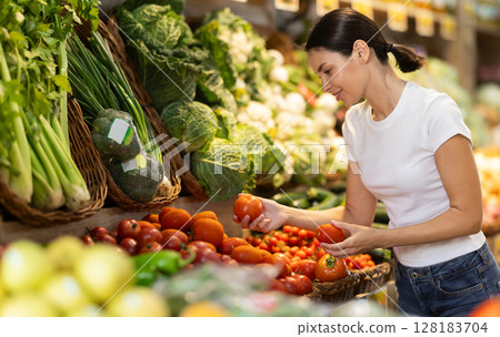 Young woman choosing red tomatoes 128183704