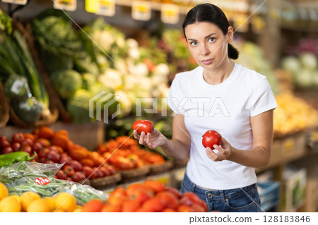 Young woman choosing red tomatoes 128183846