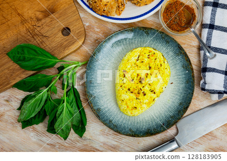 Roasted cottage cheese with turmeric and cumin on plate with baguette and greens Roasted cottage cheese with turmeric and cumin on plate with baguette and greens 128183905