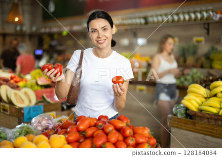 Adult woman choosing tomatoes at vegetable shop Adult woman choosing tomatoes at vegetable shop 128184034