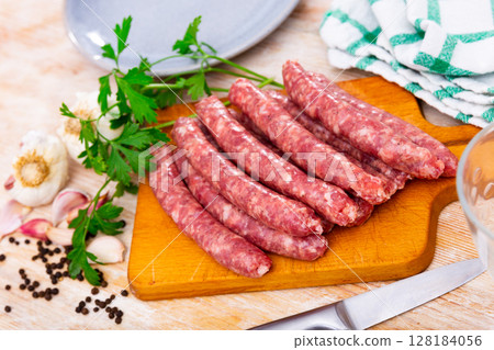 Fresh raw sausage (Longaniza) on kitchen board Fresh raw sausage (Longaniza) on kitchen board 128184056
