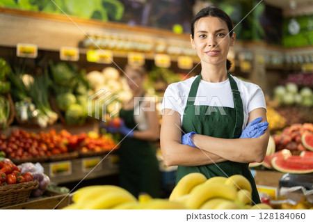 Portrait of female seller in interior of grocery supermarket Portrait of female seller in interior of grocery supermarket 128184060