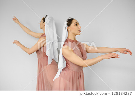 Two ballerinas standing back to back and waving hands 128184287