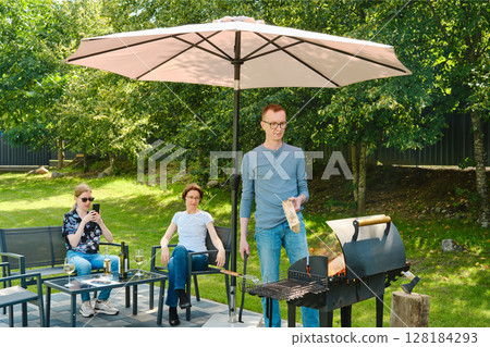 A family gathered in the backyard near a weekend barbecue. 128184293
