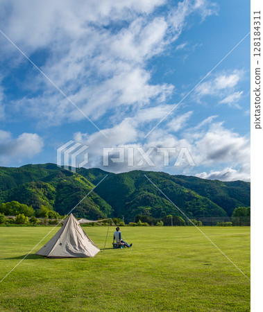 Solo camping in a large campsite on a sunny day Solo camping in a large campsite on a sunny day 128184311
