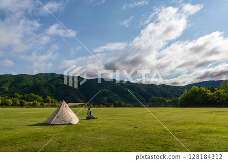 Solo camping in a large campsite on a sunny day Solo camping in a large campsite on a sunny day 128184312