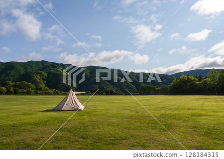 Solo camping in a large campsite on a sunny day 128184315